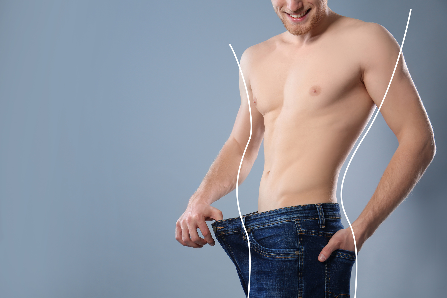 Young Man with Slim Body in Old Big Size Jeans on Grey Backgroun